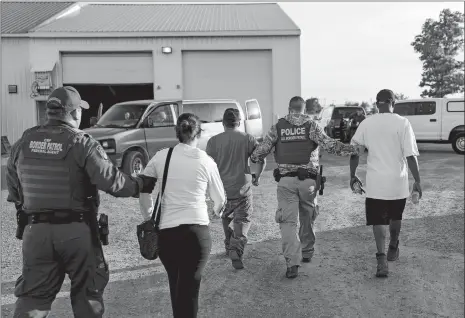  ?? JOHN MINCHILLO/AP PHOTO ?? Government agents take suspects into custody during an immigratio­n sting at Corso’s Flower and Garden Center on Tuesday in Castalia, Ohio. The operation is one of the largest against employers in recent years on allegation­s of violating immigratio­n laws.