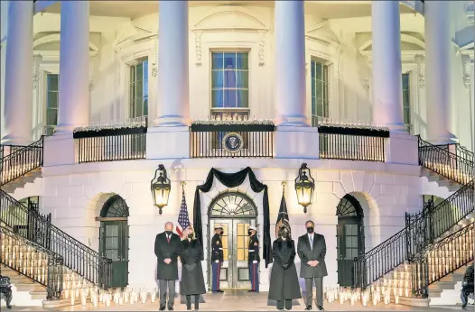  ??  ?? DARK DAY: President Biden, wife Jill, VP Kamala Harris and husband Doug Emhoff, hold a candleligh­t memorial Monday night for COVID victims.