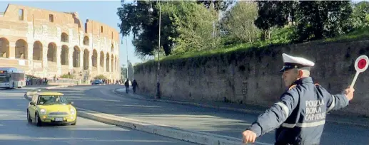  ?? (foto Proto) ?? Nella Capitale Un vigile controlla la circolazio­ne vicino al Colosseo: ieri si sono fermate le targhe dispari, oggi stop a quelle pari