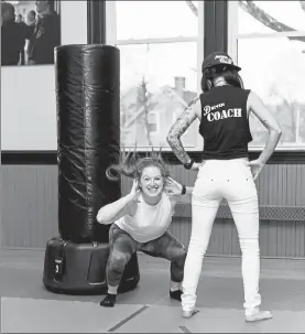  ?? COURTESY LYNN QUINLIVAN ?? Katy Kellett, left, smiles as she trains with CaraMia Pandozzi, right, at Driven Fit in Groton before attempting to break the Guinness female squat record.