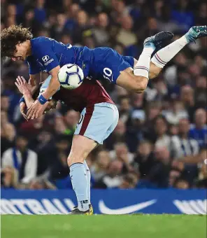 ??  ?? He ain’t heavy: Chelsea’s David Luiz flies over Burnley’s Ashley Barnes during the Premier League match at Stamford Bridge on Monday. — AP