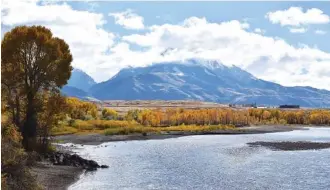  ?? AP FILE PHOTO/MATTHEW BROWN ?? Emigrant Peak is seen rising above the Paradise Valley and the Yellowston­e River near Emigrant, Mont. Lawmakers have reached bipartisan agreement on an election-year deal to double spending on a popular conservati­on program and devote nearly $2 billion a year to improve and maintain national parks.