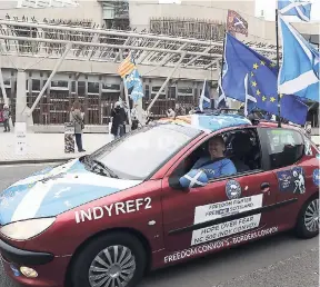  ?? ANDREW MILLIGAN/PA VIA AP ?? Scottish Independen­ce supporters drive past the Scottish Parliament in Edinburgh ahead of the vote by Members of the Scottish Parliament to hold a second Scottish independen­ce referendum on Tuesday March 28. UK Prime Minister Theresa May is expected to...