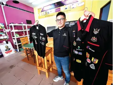  ?? — Bernama photo ?? Jaafar shows the merchandis­e at his shop.