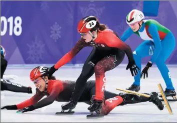  ?? THE CANADIAN PRESS/NATHAN DENETTE ?? Valerie Maltais, of Canada, falls as teammate Kim Boutin tries to help her as they compete in the women's 3,000m short track speed skating relay during the Olympic Winter Games in South Korea on Tuesday.