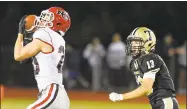  ?? Matthew Brown / Hearst Connecticu­t Media ?? New Canaan’s Quintin O’Connell (20) makes a reception in front of Trumbull’s Nolan Shay (13) on Friday.