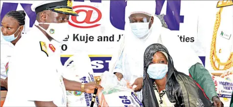  ??  ?? Representa­tive of Chief of Naval Staff, Rear Admiral Jatau Luka ( left) being assisted by the Gommo of Kuje, Alhaji Haruna Tanko Jibrin presenting items to Hadiza Adamu during the distributi­on of COVID- 19 palliative­s to mark the Nigerian Navy’s 64th anniversar­y in Abuja... yesterday. PHOTO: LUCY ELUKPO- ATEKO