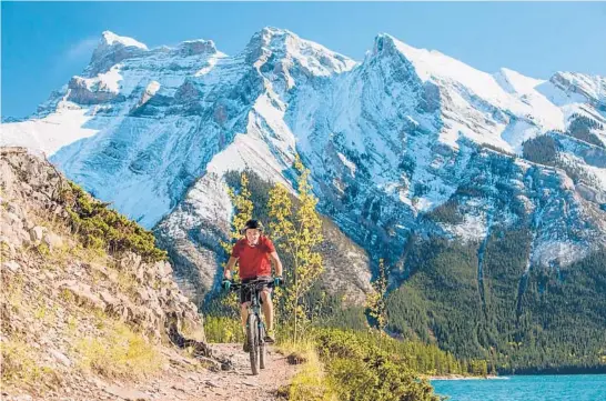  ?? PAUL ZIZKA/BANFF & LAKE LOUISE TOURISM ?? Biking near the glacial Lake Minnewanka in the Banff area.