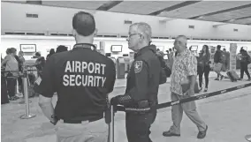  ?? ASSOCIATED PRESS ?? Airport Security and a Broward Sherriff's Deputy keep an eye on the line Tuesday at the Spirit Airlines counter at the Fort Lauderdale-Hollywood Internatio­nal Airport.