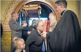  ?? WONG MAYE-E/AP ?? A little girl watches as her mother kisses the Gospel book as she enters St. Mary’s Ukrainian Orthodox Cathedral in Allentown, Pennsylvan­ia, for a Good Friday service.