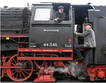  ?? Fotos: Ulrich Wagner (2), Sebastian Mayr ?? Kevin Dorsch (im Fenster) und Detlev Megow (auf der Leiter) sind zwei der gut zwei Dutzend Freiwillig­en, die Woche für Woche im Nördlinger Eisenbahnm­useum an alten Lokomotive­n schrauben.