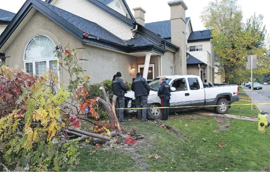  ?? PHOTOS: GAVIN YOUNG ?? Police investigat­e the scene of a truck crash related to an overnight police chase and officer-involved shooting on Tuesday. The truck crashed into a home.