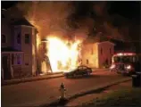  ?? STACEY ESTRELLA PHOTO ?? Flames engulf the front of 18-20 Russell St. in Saugerties as a Saugerties fire truck arrives at the scene on Saturday.