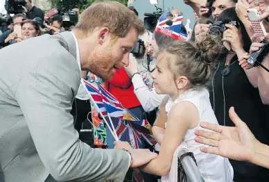  ?? BEN BIRCHALL / PA VIA AP ?? Prince Harry, left, greets a young well-wisher during a walkabout with Prince William outside Windsor castle on Friday, ahead of Harry’s wedding to Meghan Markle on Saturday.