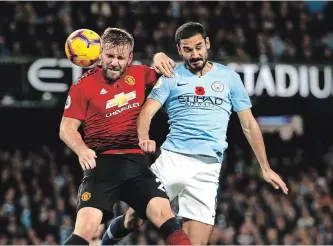  ?? DAVE THOMPSON THE ASSOCIATED PRESS ?? Manchester United’s Luke Shaw, left, and Manchester City’s Ilkay Gundogan challenge for the ball during the English Premier League soccer match between the crosstown rivals Sunday at the Etihad stadium.