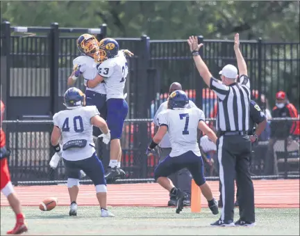  ?? TIM PHILLIS — FOR THE NEWS-HERALD ?? Carson Andonian (23) jumps and hugs Joey Grazia after Grazia intercepte­d a pass and returned it for a touchdown on Sept. 5 in Kirtland’s 35-10 win over Shaker Heights.