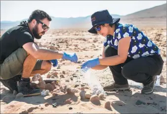  ?? MARTIN BERNETTI / AGENCE FRANCE-PRESSE ?? Biologists Cristiana Dorador (right) and Jonathan Garcia search for rock samples to analyze them in Yungay in the Atacama desert, 80 kilometers south of Antofagast­a, Chile. The Atacama is one of the most arid areas in the world and scientists believe...