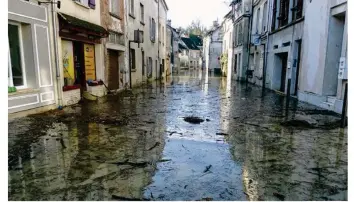  ??  ?? La rue Dam’Gilles est totalement inondée. La boutique « Comme dans un Moulin » avait déjà subi la catastroph­e de juin 2016