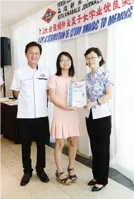  ??  ?? CHEN (kanan) menyampaik­an anugerah pelajar kepada Alistrina Vitalis, anak wartawan Utusan Borneo Vitalis Bingkasan, turut kelihatan Yong (kiri).