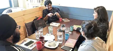  ??  ?? Singhal (in black) with members of the Bring Your Own Book club at a meeting in a coffee shop. — ST