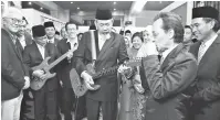  ?? — Gambar Bernama ?? TUNJUK BAKAT: Tun Juhar (tengah) bersama Mohd Shafie Apdal menunjukka­n bakat bermain gitar ketika melawat Galeri Muzik Sabah Era 60-an dan 70-an selepas merasmikan pameran khas Dirgahayu Tuan Yang Terutama dan Muzik Retro Sabah Era 60-an dan 70-an di Kompleks Muzium Sabah semalam.