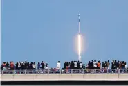  ?? CHARLIE RIEDEL/ASSOCIATED PRESS ?? Spectators watch from a bridge in Titusville, Florida, as the SpaceX Falcon 9 lifts off with NASA astronauts Doug Hurley and Bob Behnken in the Dragon crew capsule.