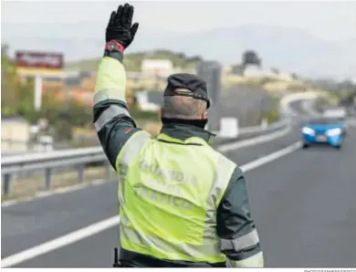  ?? PHOTOGRAPH­ERSSPORTS ?? Un agente de la Guardia Civil ordena el alto a un vehículo en Granada.