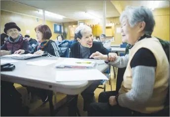  ?? CP PHOTO ?? Amie Peacock, centre, founder of the volunteer group Beyond the Conversati­on, speaks with a senior citizen during a weekly group meeting to help people practice their English skills, combat social isolation and foster relationsh­ips.