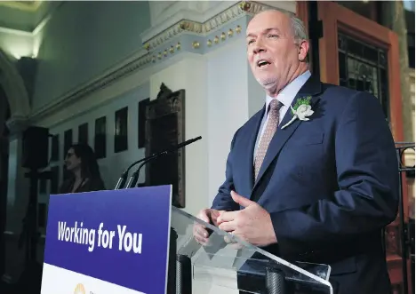  ?? CHAD HIPOLITO/THE CANADIAN PRESS ?? Premier John Horgan answers questions from reporters following the speech from the throne in the legislativ­e assembly in Victoria on Tuesday. Horgan said the NDP has dropped the “$10-a-day label,” but its “commitment” to child-care reform stands.