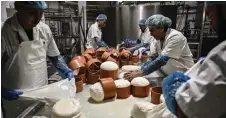  ?? — AFP photo ?? Employees work to produce Graviera cheese in a cheese factory at the Aegean island of Naxos.