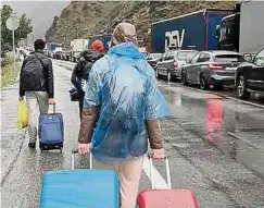  ?? Fotos: AFP ?? An der russisch-georgische­n Grenze kommt es derzeit zu kilometerl­angen Staus, weil viele Russen aus Angst vor einer Einberufun­g ins Ausland fliehen wollen.