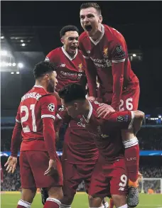  ?? Getty ?? Andrew Robertson (No 26) and Trent Alexander-Arnold jump in the celebratio­n of Roberto Firmino (No 9) at Etihad Stadium