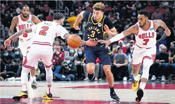  ?? NAM Y. HUH/AP ?? Pacers guard Chris Duarte chases the ball between Bulls defenders Lonzo Ball (left) and Troy Brown Jr. during the first half Monday at the United Center.