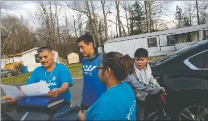  ??  ?? Prisi Hernandez (left) and Laura Hernandez, both with the organizati­on Siembra NC, help Nery Ocampo, 19, (center) to register to vote as Irvin Bahena, 10, stops March 11 to watch from his bicycle in a largely Latino trailer community in Burlington, N.C. It will be Ocampo’s first time voting. “I didn’t have time to register before,” says Ocampo, “it’s important for Latinos who can to vote, in order to help those who can’t.” (AP/Jacquelyn Martin)