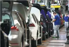  ?? SWEN PFOERTNER / POOL VIA REUTERS ?? Workers at the Volkswagen assembly line in Wolfsburg, Germany, in April.