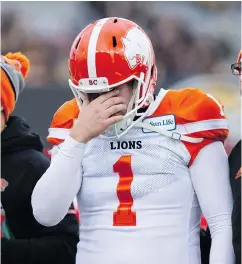  ??  ?? B.C. Lions kicker Ty Long holds his head while walking off the field after being hit during the second half of Sunday’s division semifinal game against the Tiger-Cats.