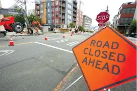  ?? AP PHOTO/TED S. WARREN ?? A sign indicates ongoing work on a project to replace water main pipes June 15 in downtown Tacoma, Wash.