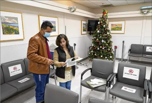  ?? PHOTOS BY ERIC RISBERG/ASSOCIATED PRESS ?? Mohammad Attaie and his wife Deena, newly arrived from Afghanista­n, look over documents they need assistance with at the Valley Health Center Tb/refugee Program on Dec. 9 in San Jose, Calif.