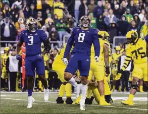  ?? Tom Hauck / Getty Images ?? Defensive lineman Jeremiah Martin (3) and Bralen Trice (8) of the Washington Huskies celebrate their sack of Oregon Ducks quarterbac­k Bo Nix (on ground) during the second half Saturday in Eugene, Ore.