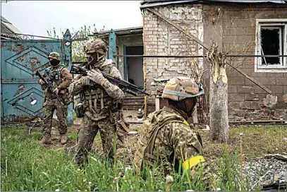  ?? BERNAT ARMANGUE / AP ?? Ukrainian National Guard patrol during a reconnaiss­ance mission in a recently retaken village on the outskirts of Kharkiv, east Ukraine, Saturday.