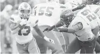  ?? DUANE BURLESON/AP ?? RB DeeJay Dallas evades Toledo defensive lineman Tuzar Skipper during the first half of Miami’s 49-24 victory over the Rockets.