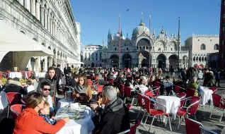  ??  ?? Prima del virus Turisti in piazza San Marco a Venezia durante le ultime vacanze di fine anno