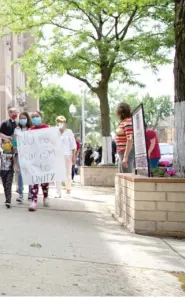  ?? ANTHONY VAZQUEZ/SUN-TIMES ?? Demonstrat­ors hold up signs that read ‘‘Latina mothers supporting African American mothers, BLM’’ and ‘‘No to racism, yes to unity’’ on Friday.