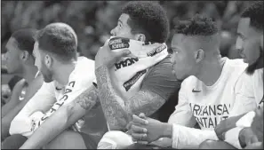  ?? NWA Democrat-Gazette/J.T. WAMPLER ?? Dustin Thomas (center) and his teammates watch the final moments of Arkansas’ loss to North Carolina on Sunday in Greenville, S.C. The Razorbacks have never beaten a No. 1 seed in the NCAA Tournament.