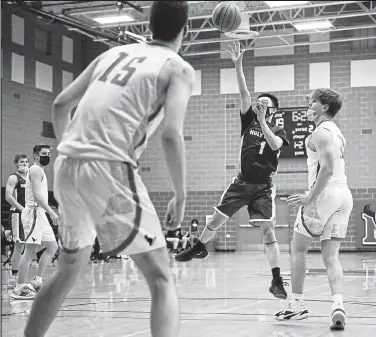  ?? Timothy Hurst / Staff Photograph­er ?? Holy Family’s Eric Quintana, center, puts up a floater in the lane against Mead on Friday night at Mead High.