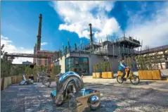  ?? WU HUI/FOR CHINA DAILY ?? A tourist rides a bike through the 798 Art Zone in Beijing, which was built on the site of an abandoned factory and is now one of the city’s best-known tourist attraction­s. Ma Ying, professor at Beijing and architectu­re