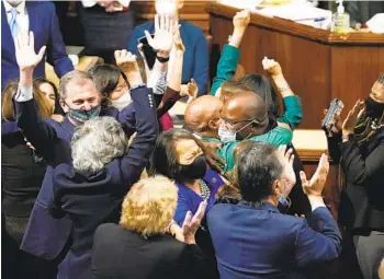  ?? J. SCOTT APPLEWHITE AP ?? House Democrats celebrate after passage of President Joe Biden’s expansive social and environmen­t bill at the Capitol in Washington on Friday. The measure passed on a 220-213 vote with all Republican­s opposed.