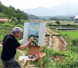  ??  ?? French artist Rémy Aron paints outdoors in Wenzhou, southeast China’s Zhejiang Province in May 2018.