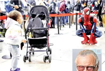  ?? — Reuters photo ?? A baby boy cries as a man in a Spider-Man costume poses next to him at Tokyo Comic Con at Makuhari Messe in Chiba, Japan yesterday.