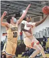  ?? PETE BANNAN – MEDIANEWS GROUP ?? Chester’s Fareed Burton, right, goes to the net with West Chester Rustin’s Ryan Seelaus defending in the third quarter Tuesday night. The Clippers went on to a 62-46victory to win the District 1Class 5A title.